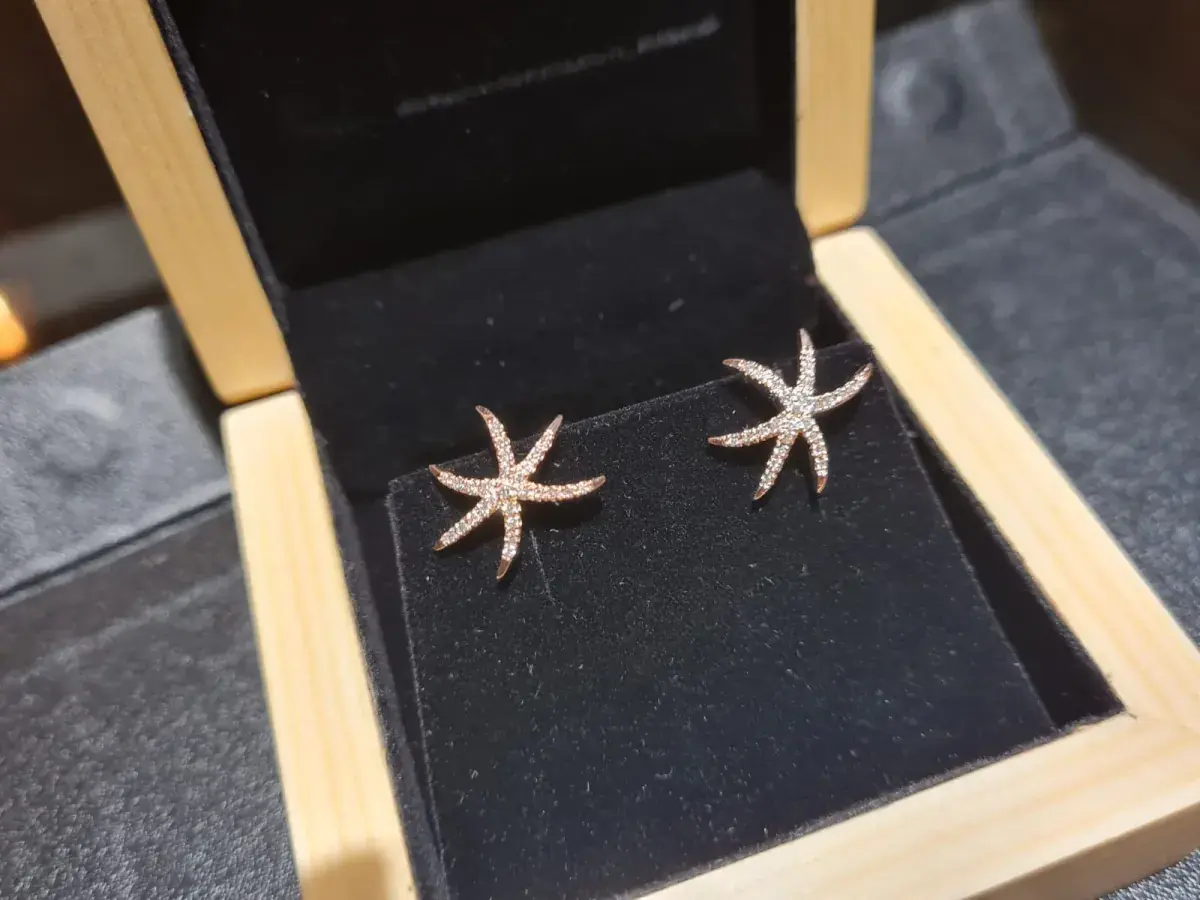 Rose gold pavé diamond starfish stud earrings in a wooden presentation box