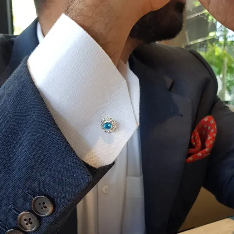Blue topaz and silver dress cufflink worn on a white French cuff